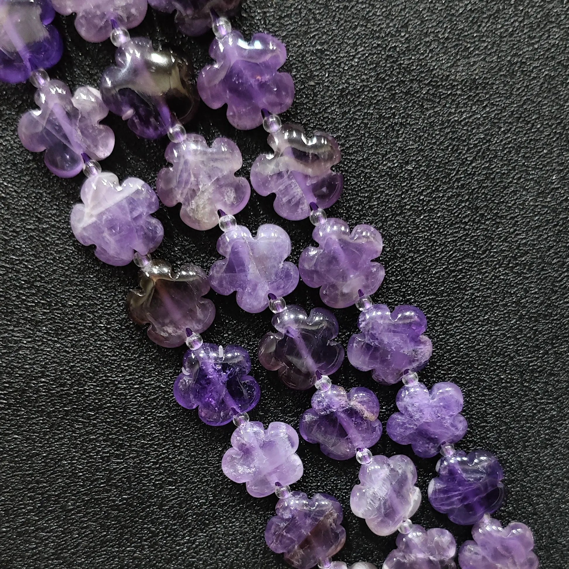 Macro closeup of amethyst quartz plum blossom carved beads 15mm showing purple crystal clarity
