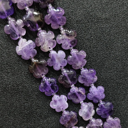 Macro closeup of amethyst quartz plum blossom carved beads 15mm showing purple crystal clarity