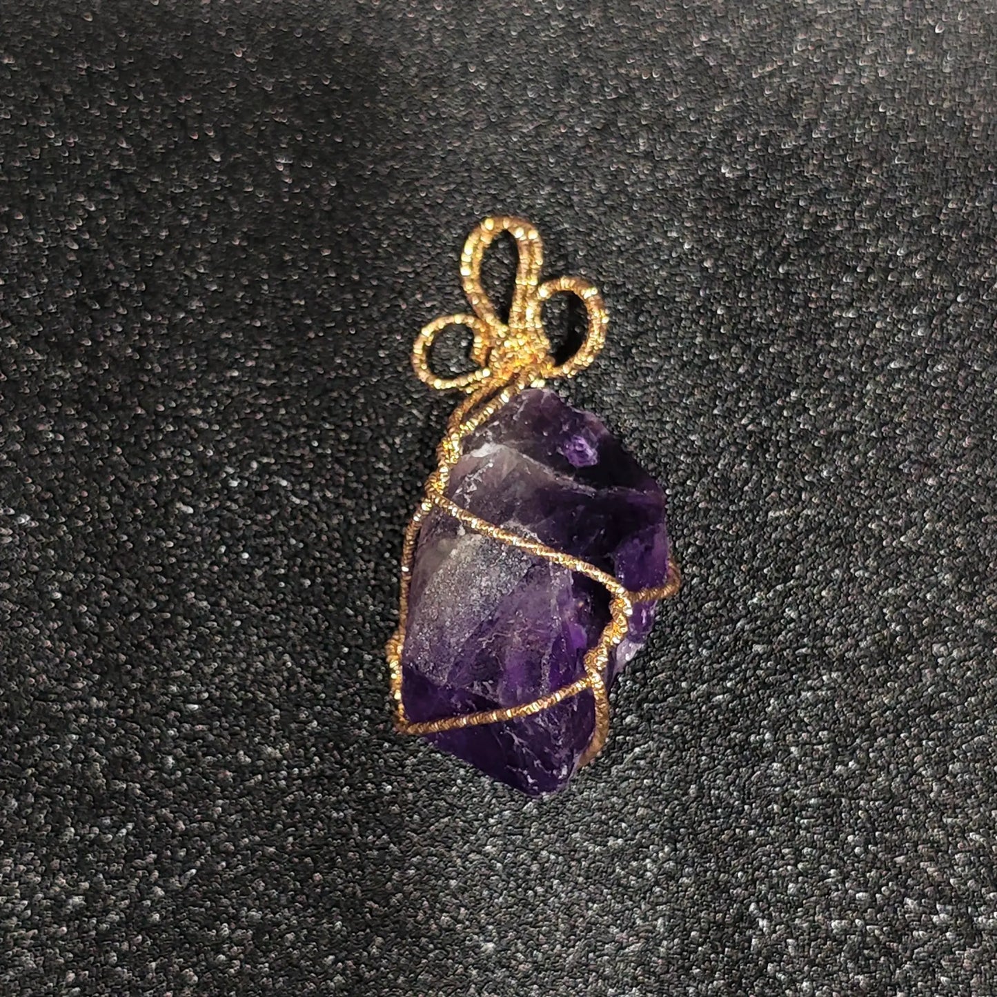 Raw purple amethyst crystal nugget with heavy cloud inclusions wrapped in gold-tone craft wire