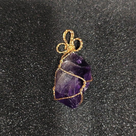 Raw purple amethyst crystal nugget with heavy cloud inclusions wrapped in gold-tone craft wire