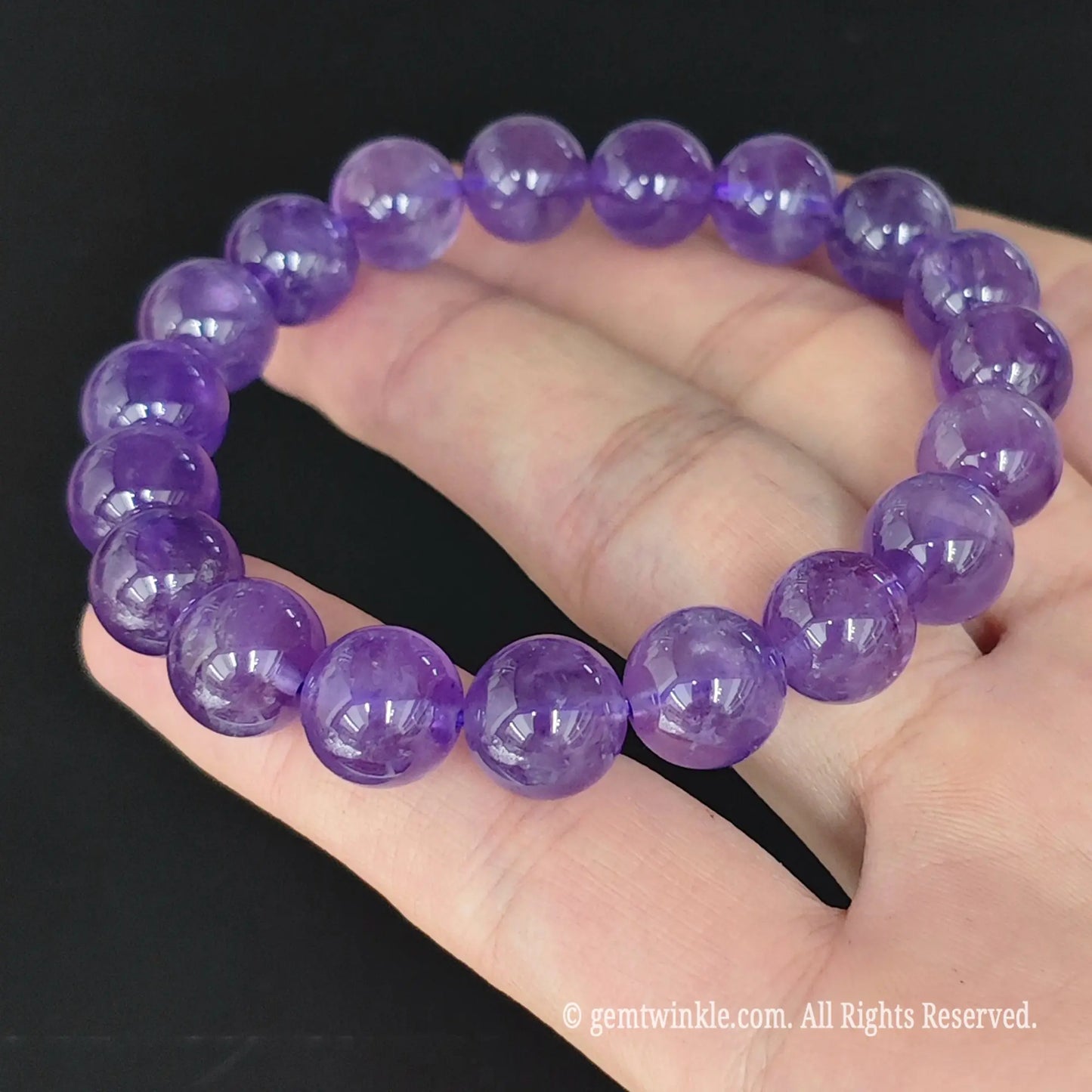 purple amethyst round bead stretch bracelet displayed in open hand