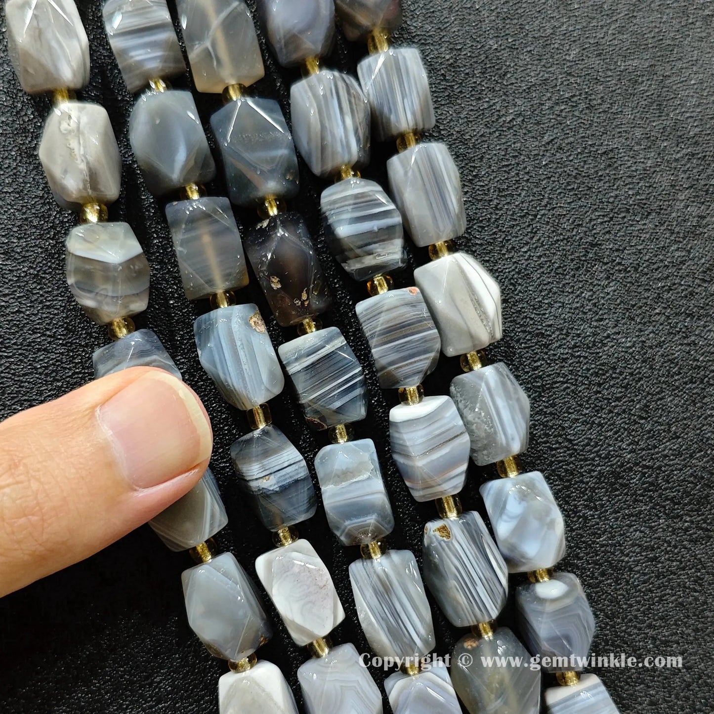 angle view of faceted persian agate barrel beads highlighting geometric cut