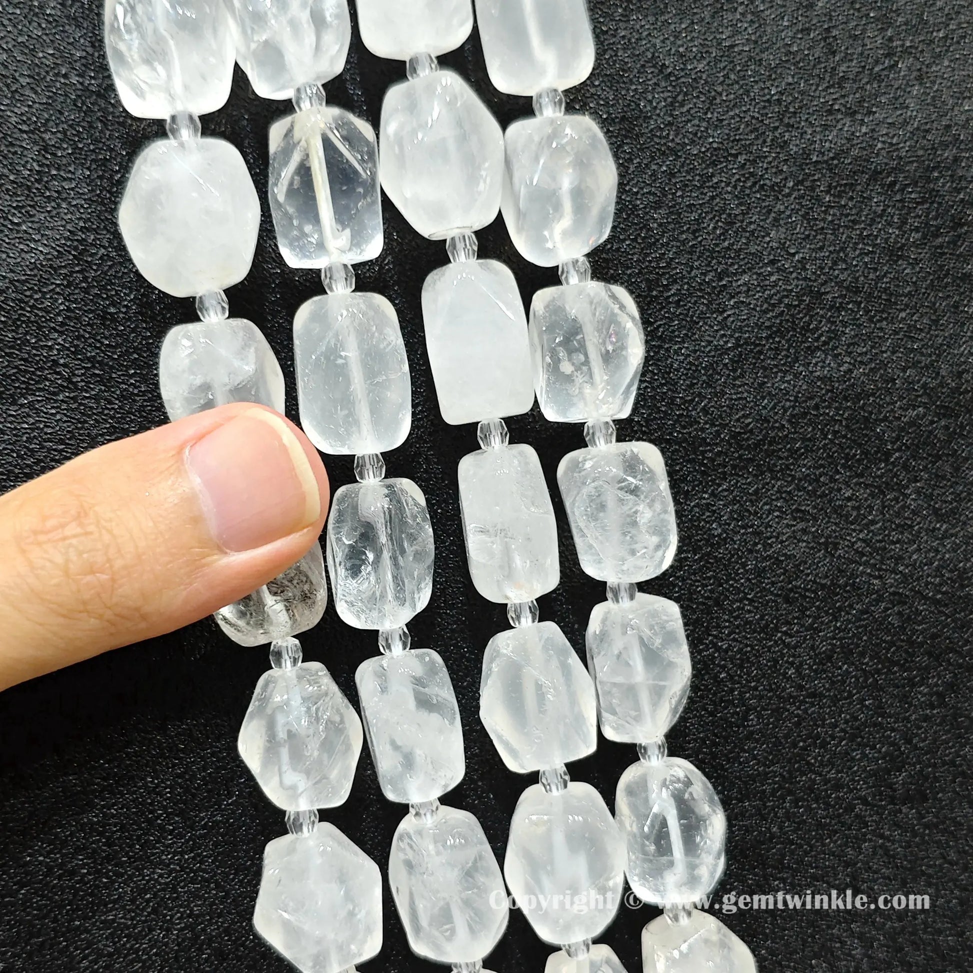 angle view of included clear quartz faceted barrel beads catching light