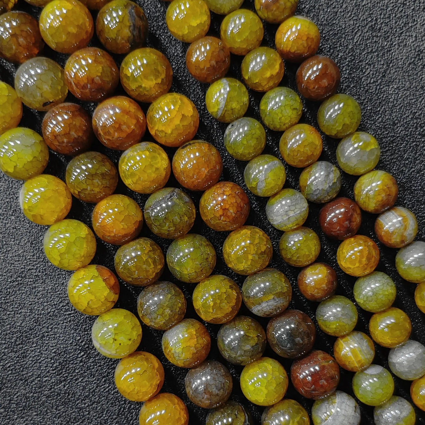 Diagonal view of antique yellow dragon vein agate beads highlighting bold honey orange colors and webbed scales