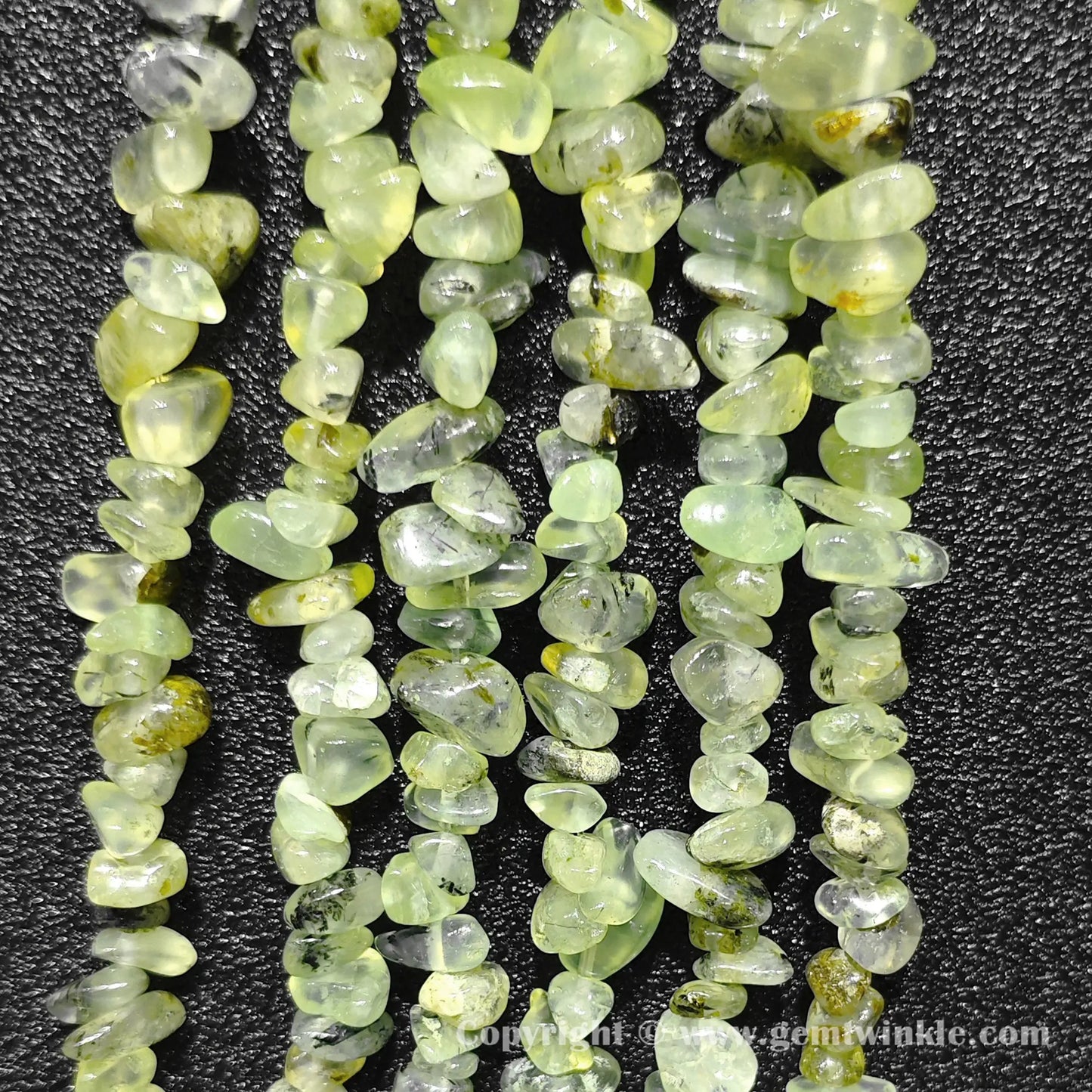 Long strand layout of apple green translucent prehnite chip beads for craft making