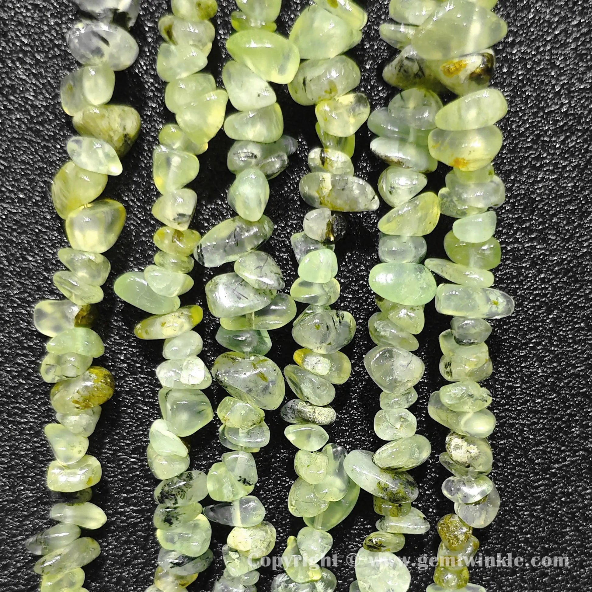 Long strand layout of apple green translucent prehnite chip beads for craft making