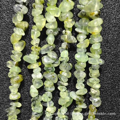 Long strand layout of apple green translucent prehnite chip beads for craft making