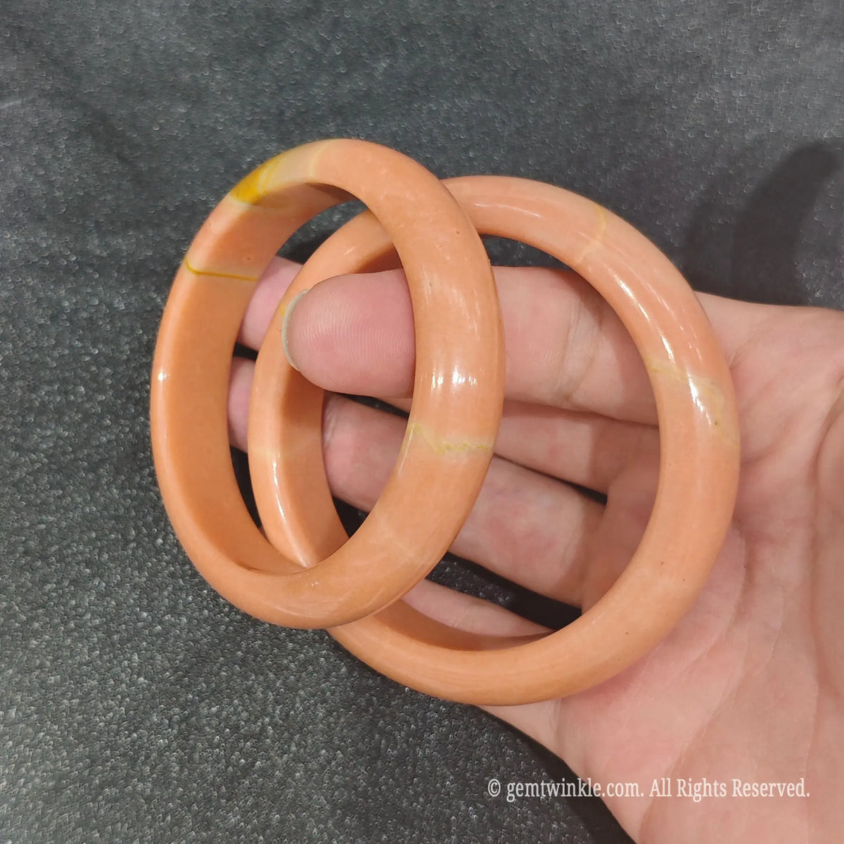 Close-up of smooth carved Apricot Quartz gemstone bangle highlighting polish quality and rich amber orange color