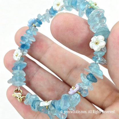 Close up preview of aquamarine chip bracelet showing flower spacer beads and lobster clasp hardware