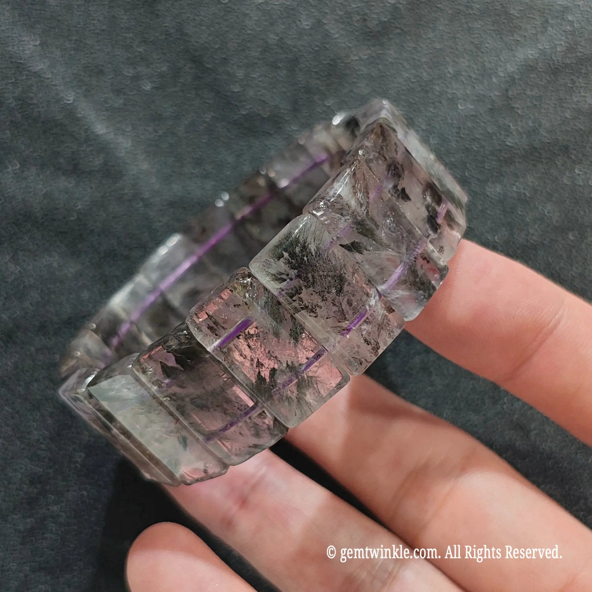 Side view of a minimalist auralite 23 rectangle stretch wristlet displaying raw mineral inclusions inside purple quartz