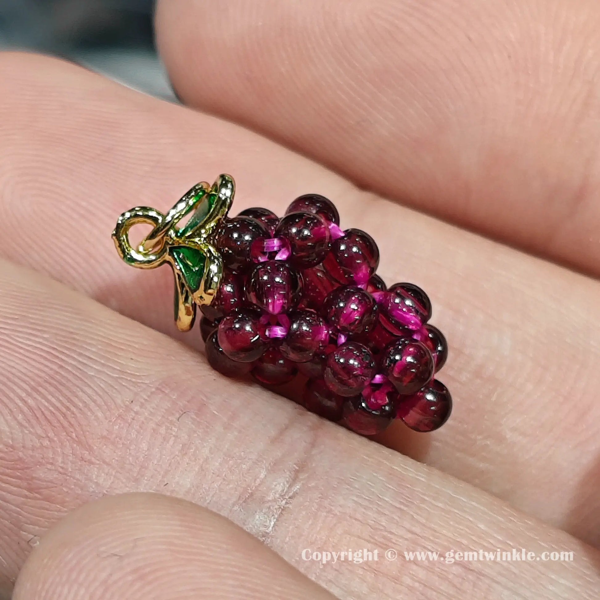 Front view of authentic garnet grape pendant bead showing size proportions and secure top hanging loop on finger