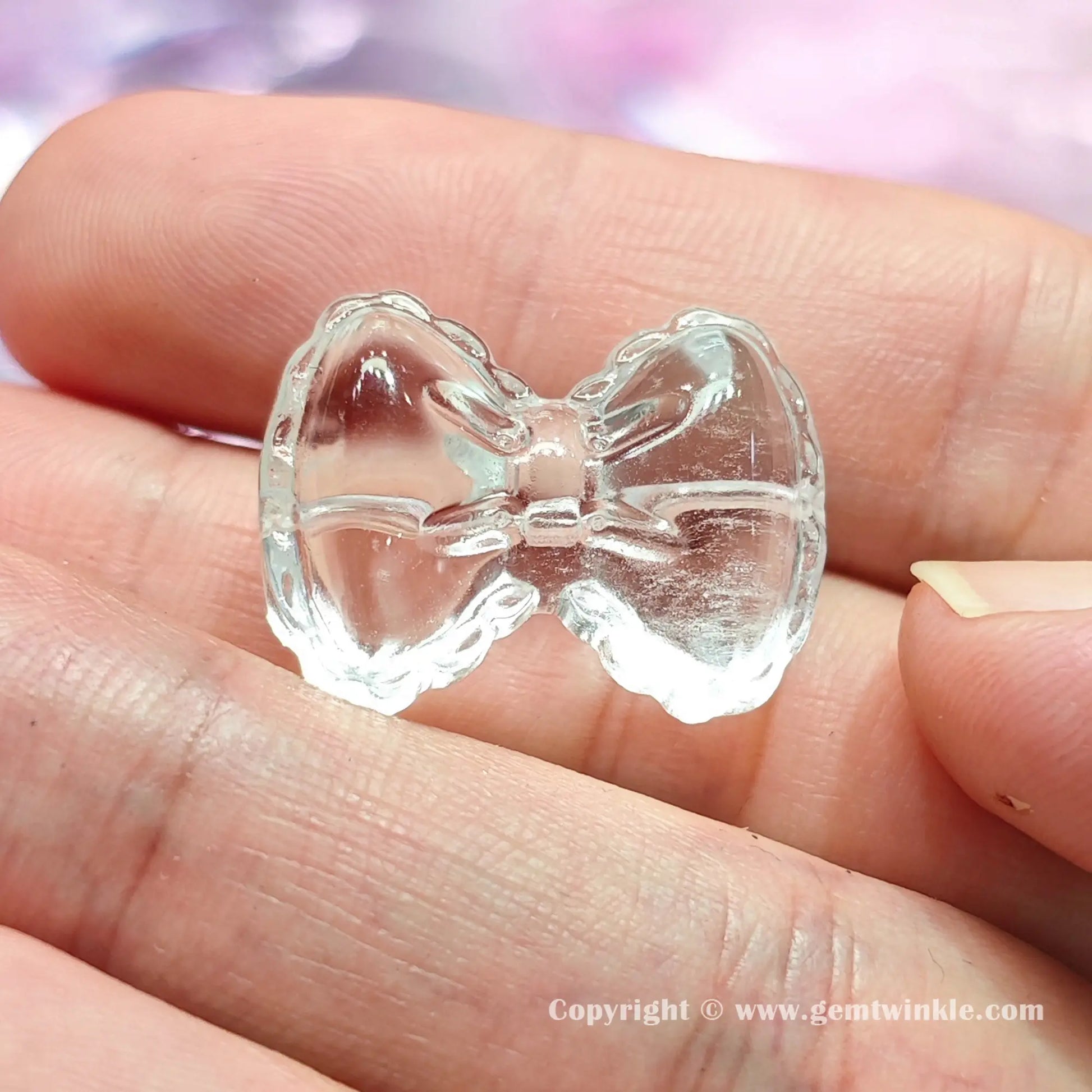 Front view of authentic translucent quartz bowknot bead displaying 17mm and 24mm size proportions on fingers