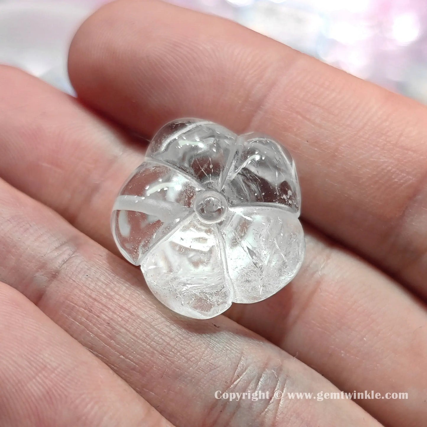 Back view of authentic translucent quartz rose flower bead displaying center drill hole and 22mm proportions on hand