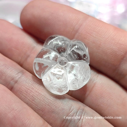 Back view of authentic translucent quartz rose flower bead displaying center drill hole and 22mm proportions on hand