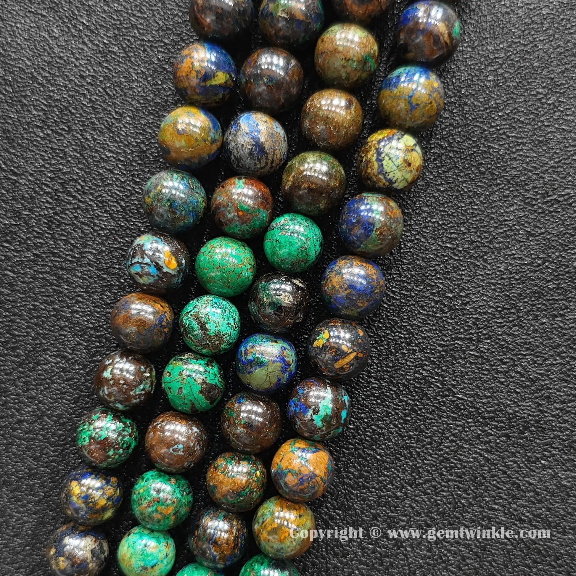 Parallel view of natural azurite malachite round bead strands placed on dark textured background