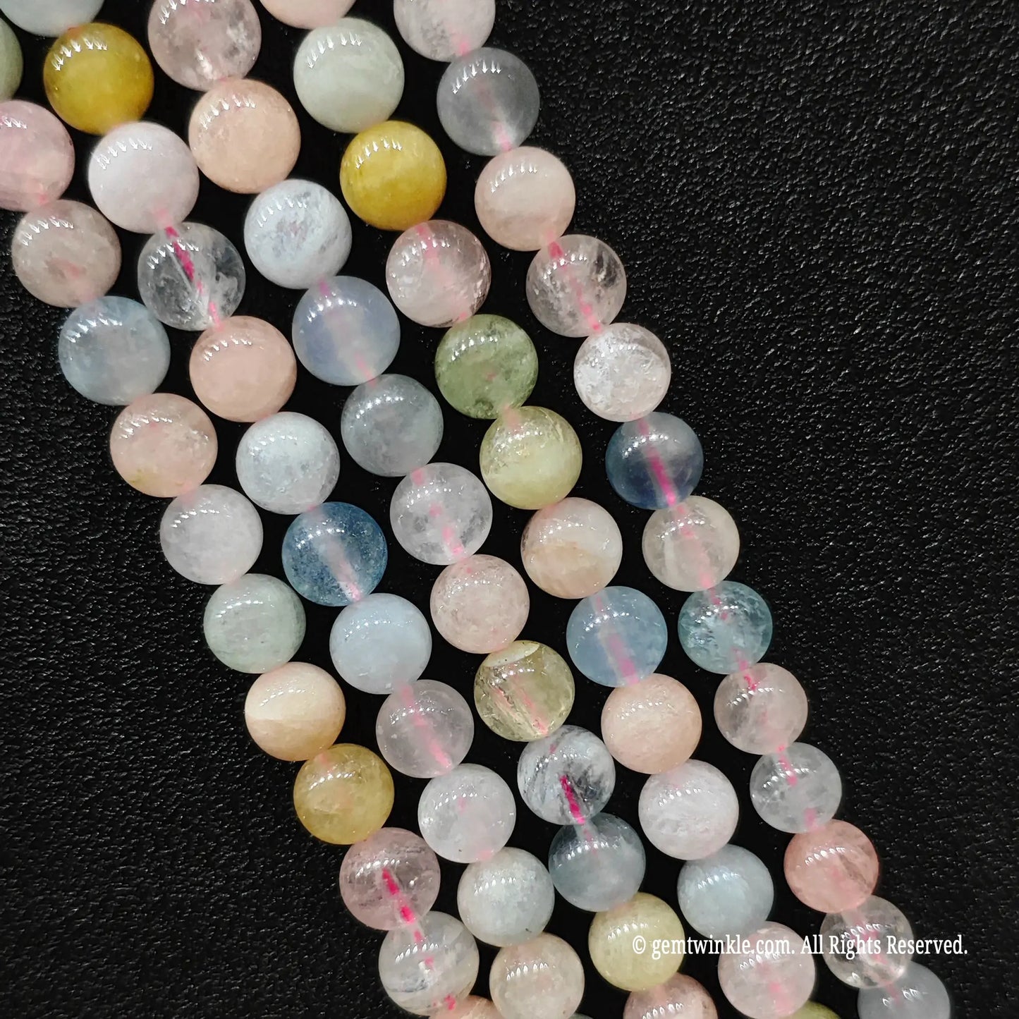 Four clean strands of B plus tier pastel multi color morganite crystal beads highlighting high gloss surface polish and smooth round cut