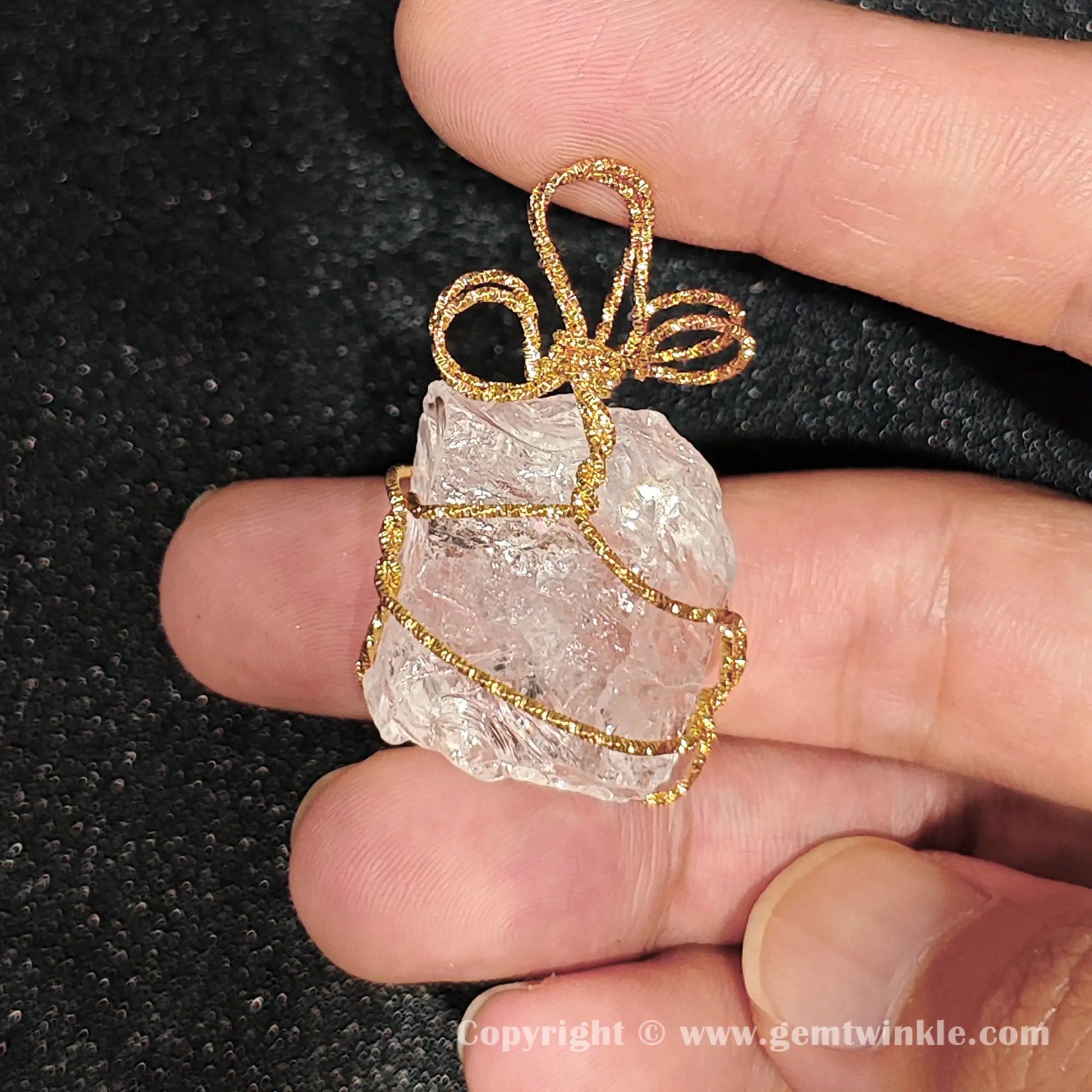 Reverse side view of 30mm clear quartz raw specimen enclosed within gold-tone wire frame