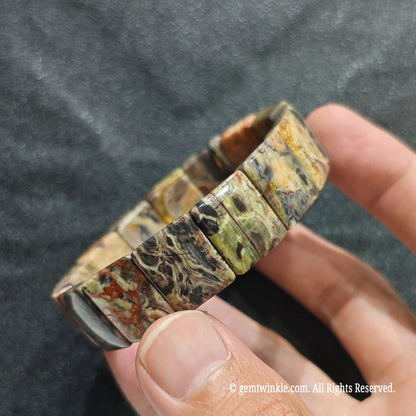 Close up view of banded earth agate rectangular bead band showing smooth polish and rich lace matrix