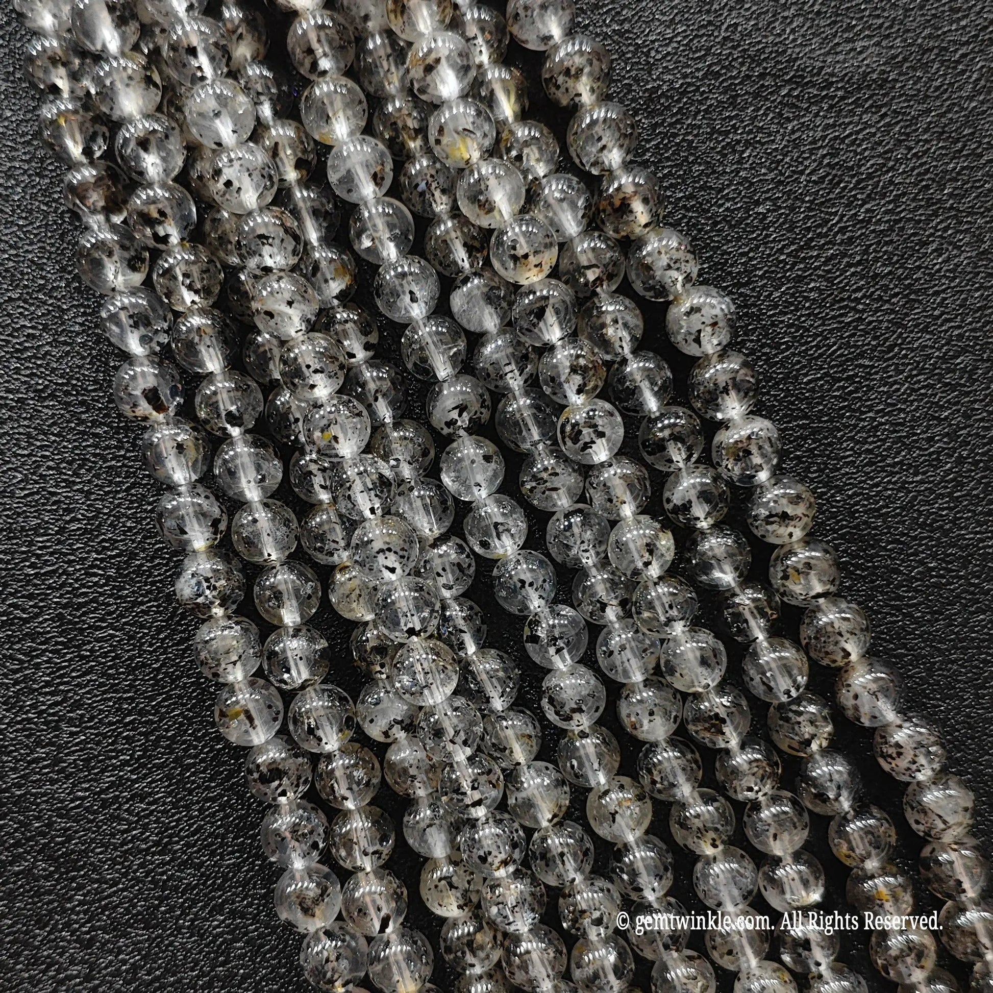 Biotite quartz crystal beads strands showcasing clear quartz structures loaded with organic dark mica minerals