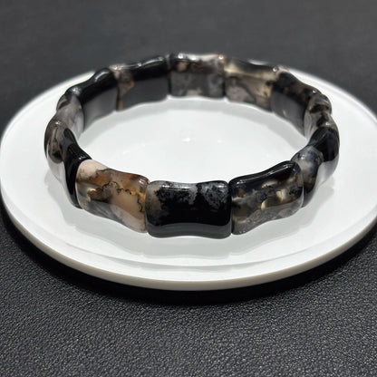 Lifestyle Photo of Black Sakura Agate Bamboo Bangle on Table