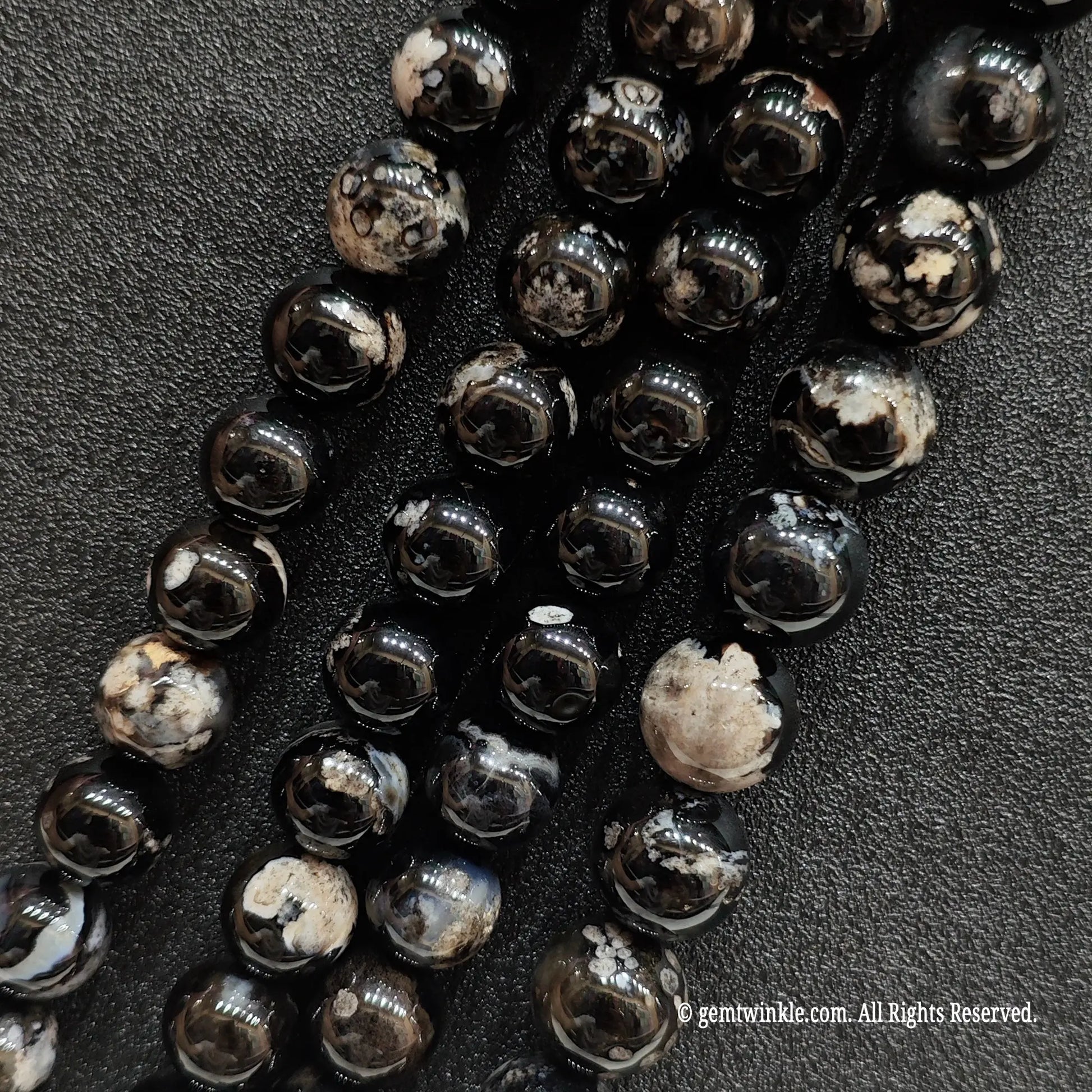 Three parallel wholesale strands of dyed black flower agate crystal beads with a natural chalcedony base to verify pattern distribution
