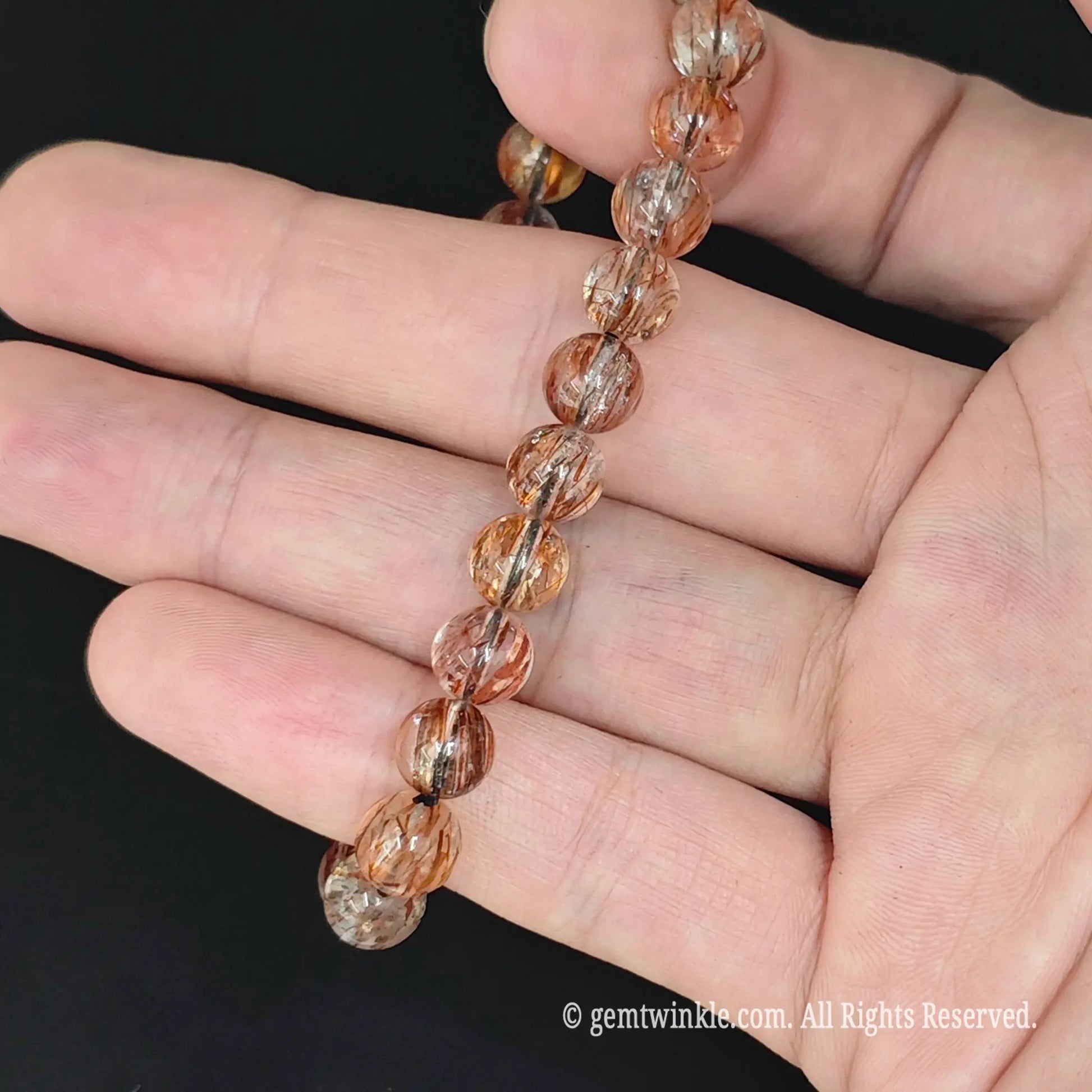 vertical view of black gold super seven round bead stretch bracelet