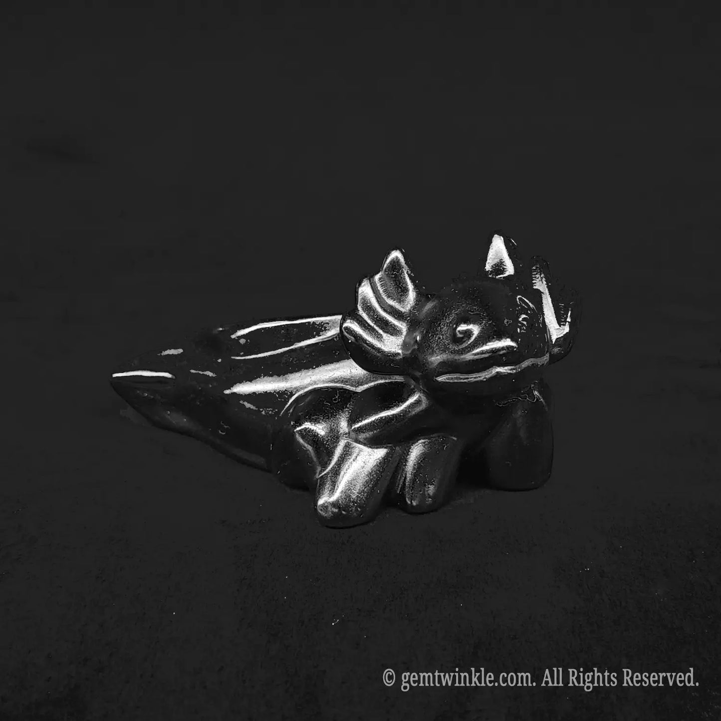 Glossy black obsidian axolotl desk pet carving showing smooth polished reflective body curves