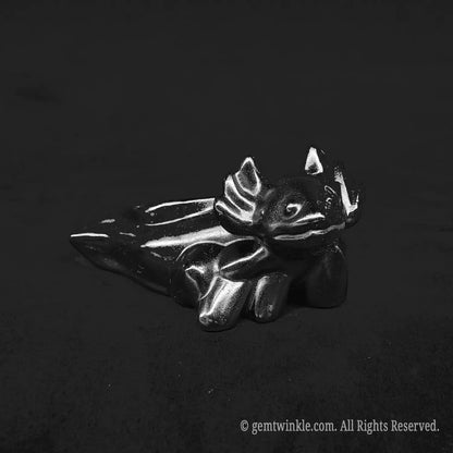 Glossy black obsidian axolotl desk pet carving showing smooth polished reflective body curves