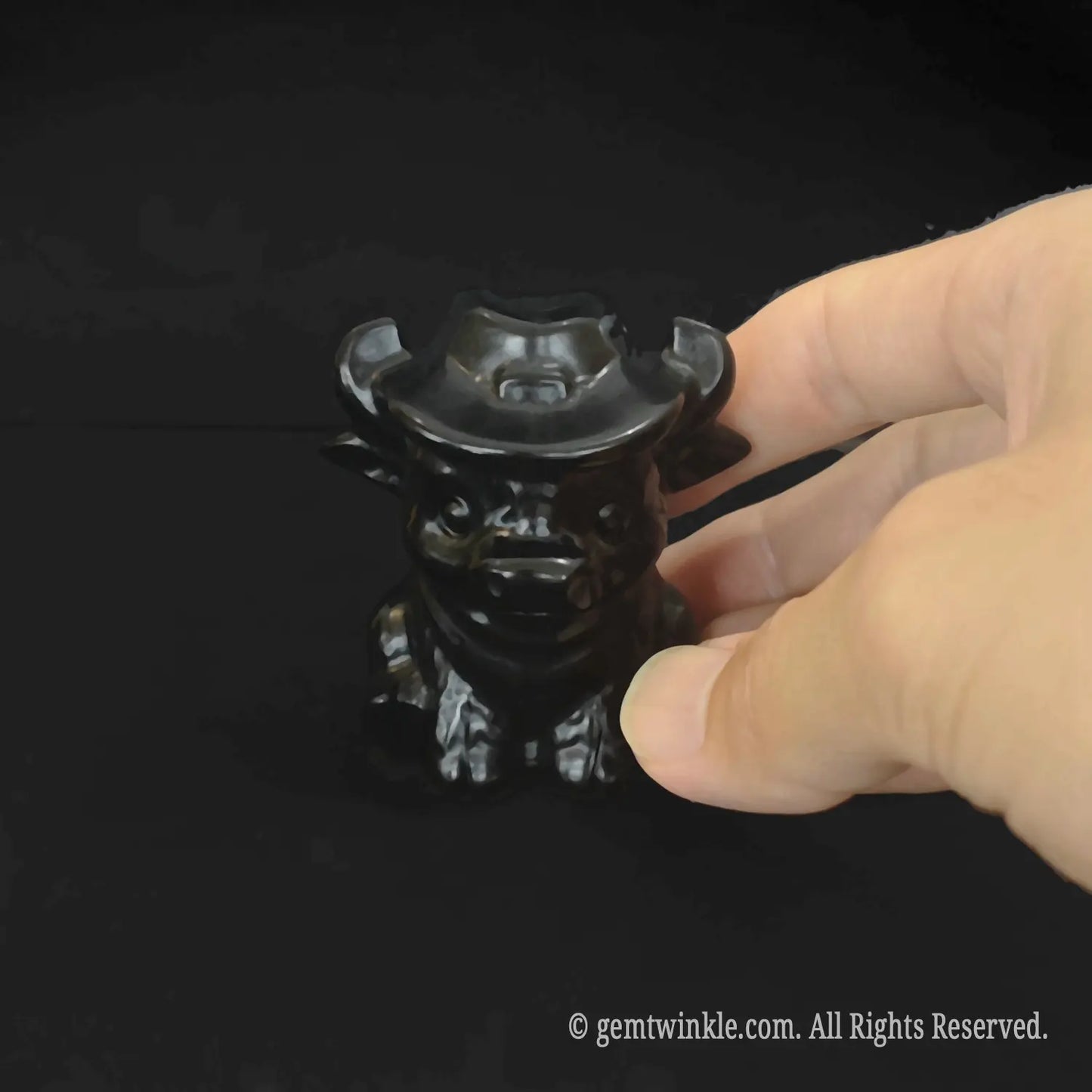 Glossy natural black obsidian crystal cowboy calf carving with reflective volcanic glass polish
