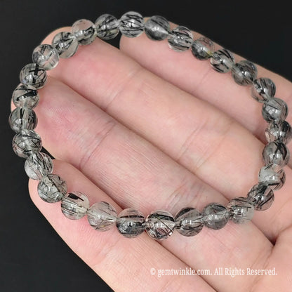 top view of black rutilated quartz bead stretch bangle on palm