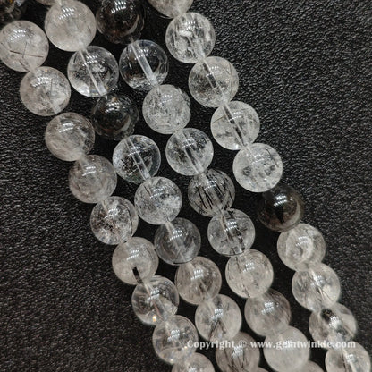 Detailed perspective of real black rutilated quartz beads in 5mm, 9mm, 11mm, and 13mm sizing options strung on jewelry wire