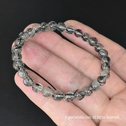 black rutilated quartz round bead stacking bracelet held across fingers