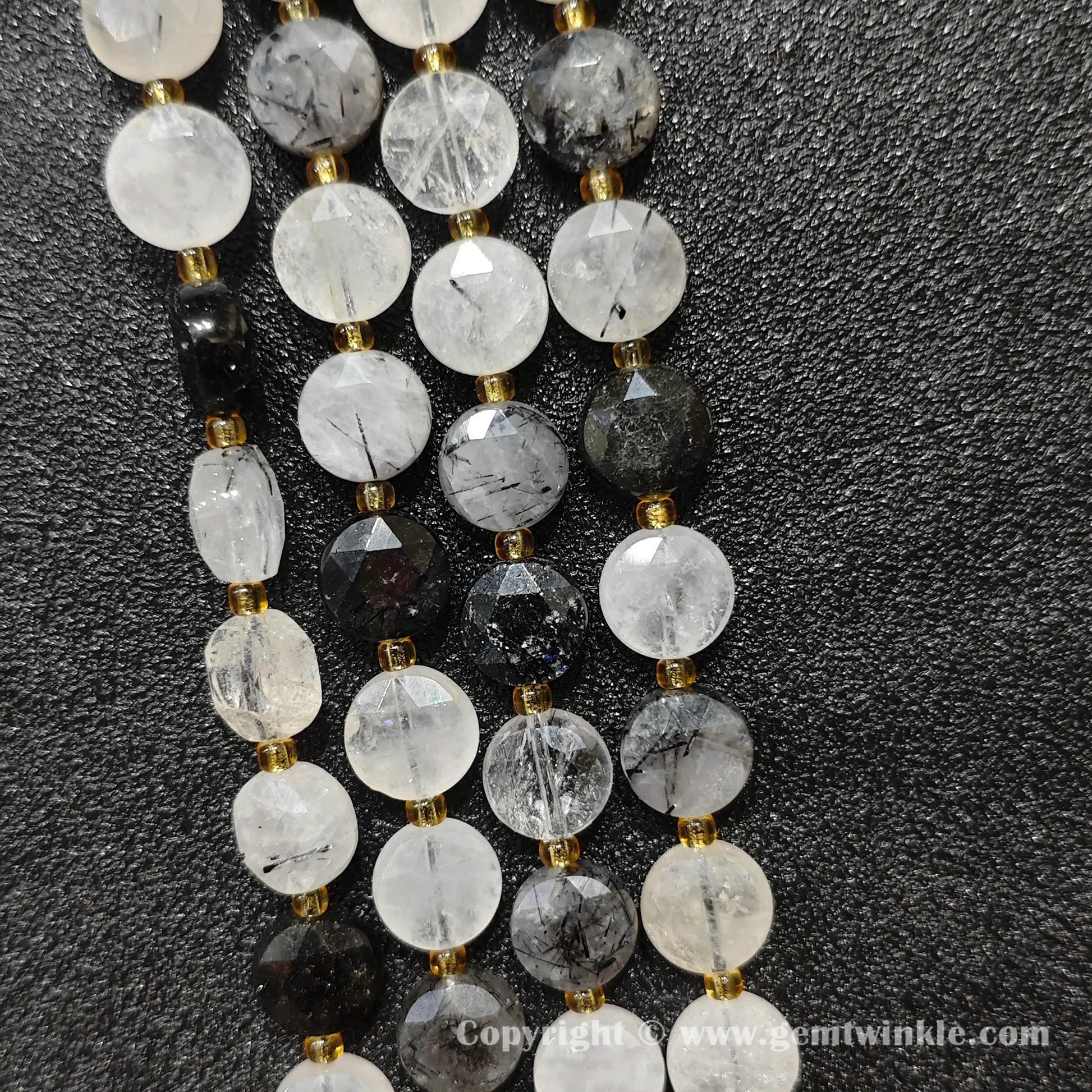 Side angle view of black rutile quartz faceted flat disc beads displaying bead thickness