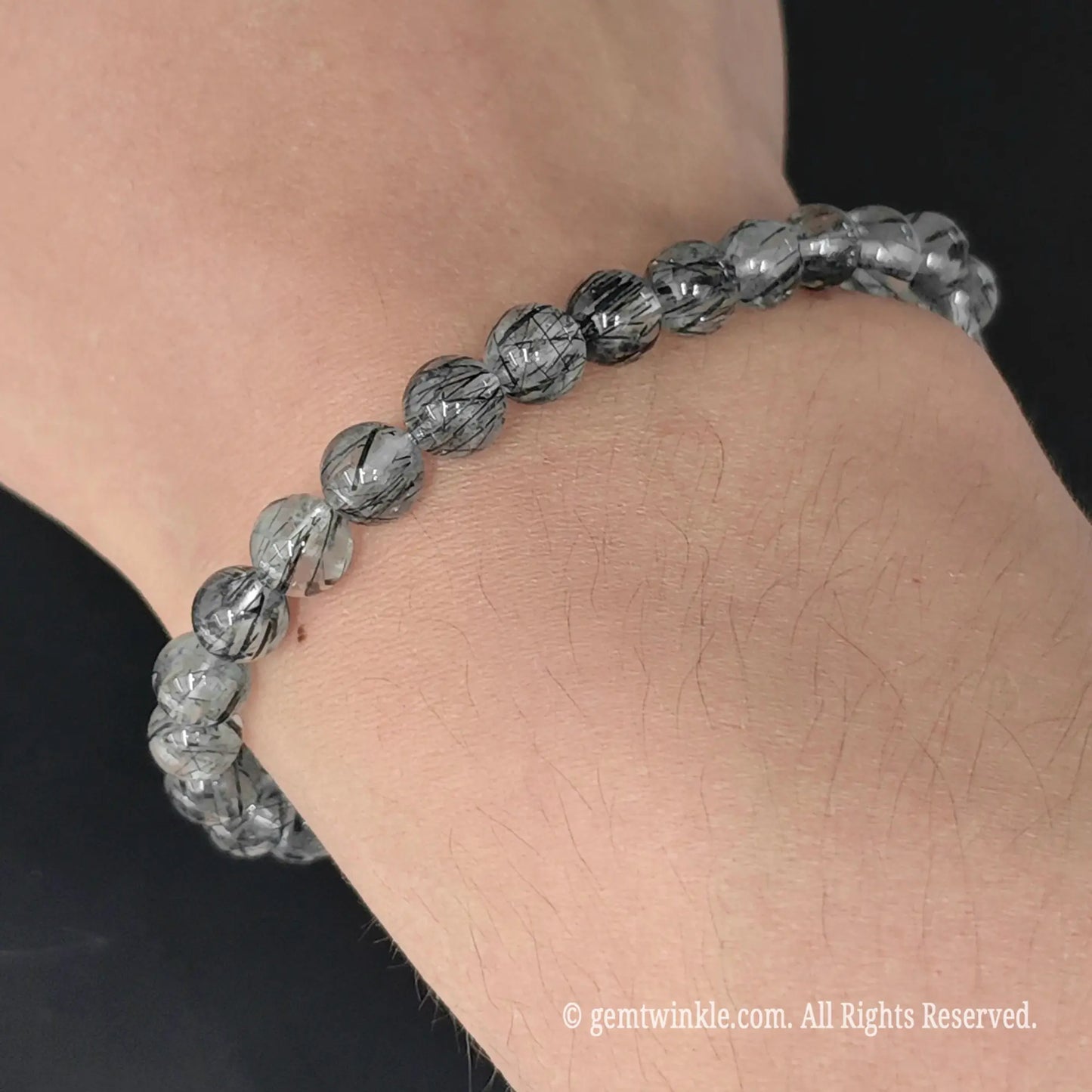 side view of black tourmaline quartz round bead stretch bracelet worn on wrist