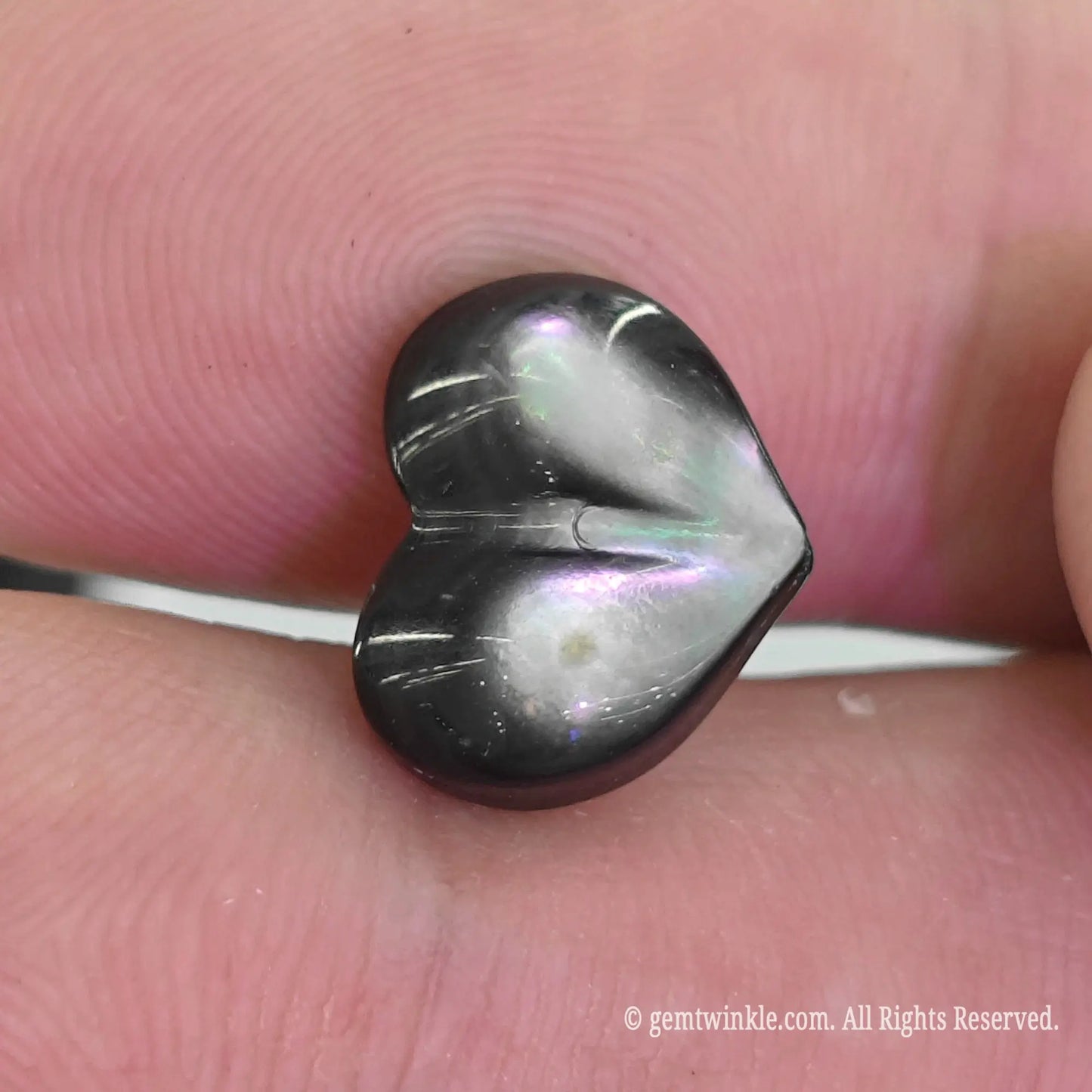 Black MOP puffy heart bead top angle view showing vertical top to bottom straight drill hole