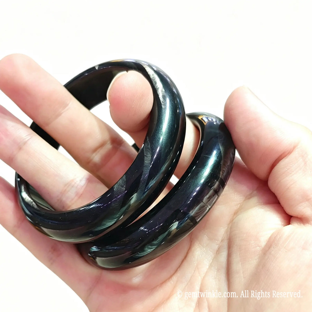 Black hypersthene quartz band held in hand showing metallic schiller and single piece selection