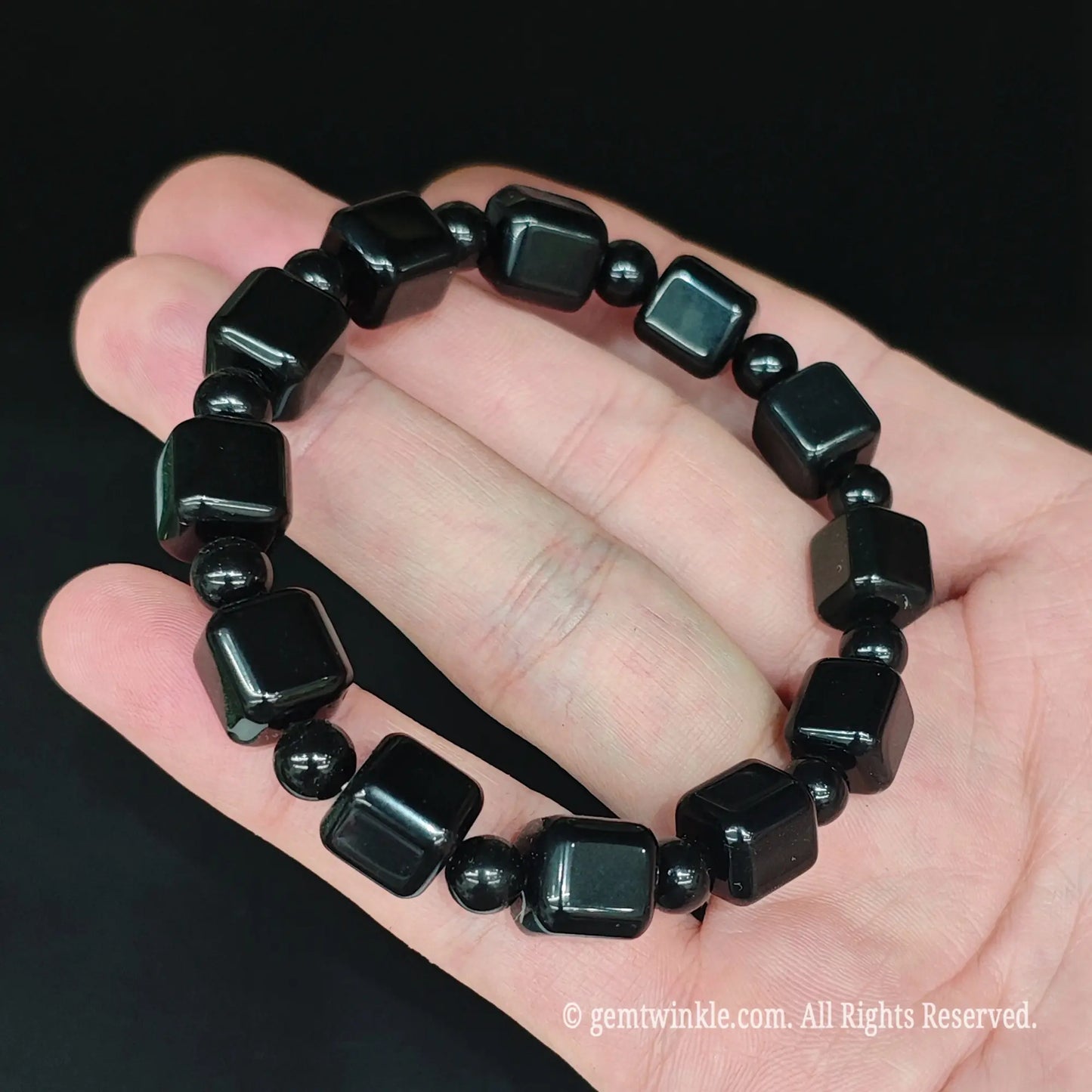 Black obsidian 10mm rounded block bracelet styled on hand showing jet black color and comfortable 17cm fit