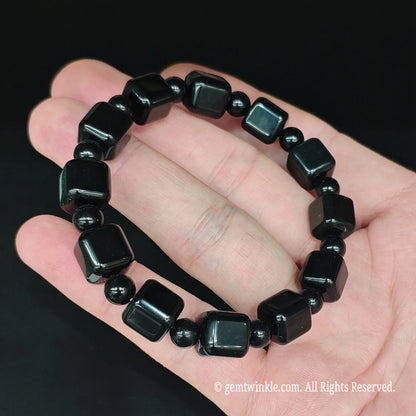Black obsidian 10mm rounded block bracelet styled on hand showing jet black color and comfortable 17cm fit