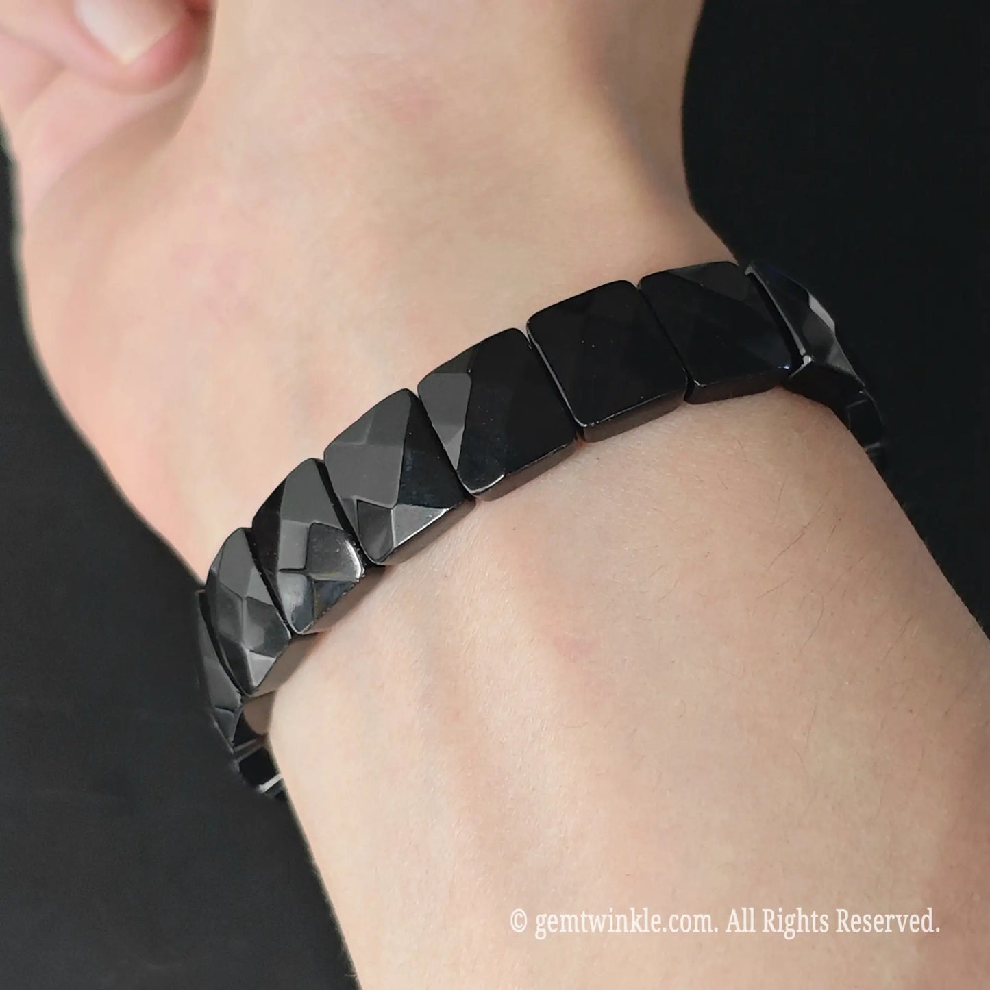 Black obsidian 12mm faceted square bead stretch bracelet styled on wrist displaying lustrous jet black surface