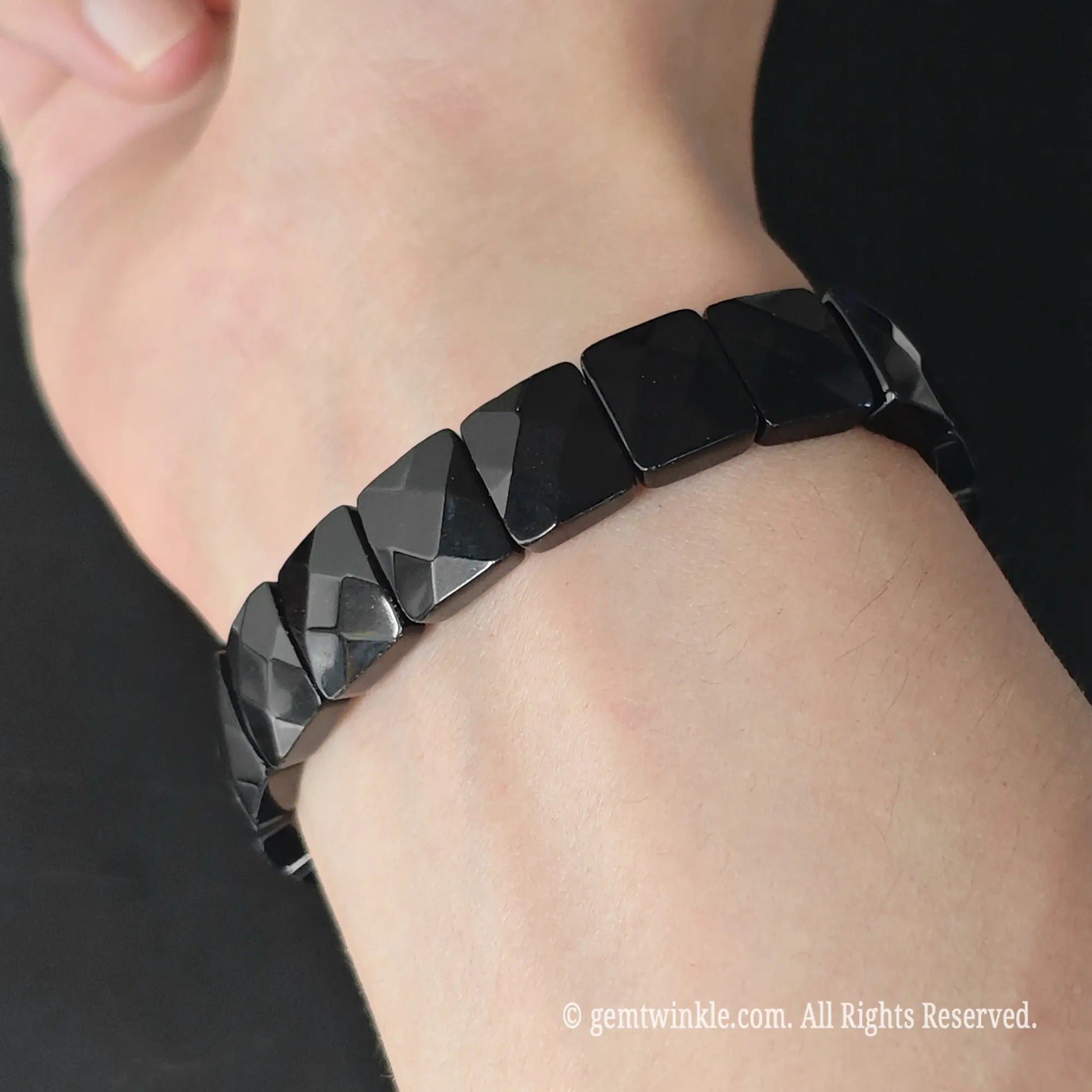 Black obsidian 12mm faceted square bead stretch bracelet styled on wrist displaying lustrous jet black surface