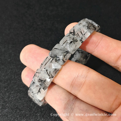 natural black rutilated quartz plate bracelet displayed across fingers highlighting quartz transparency