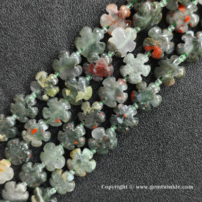 Angled view of natural African bloodstone floral carved gemstone strands laid together