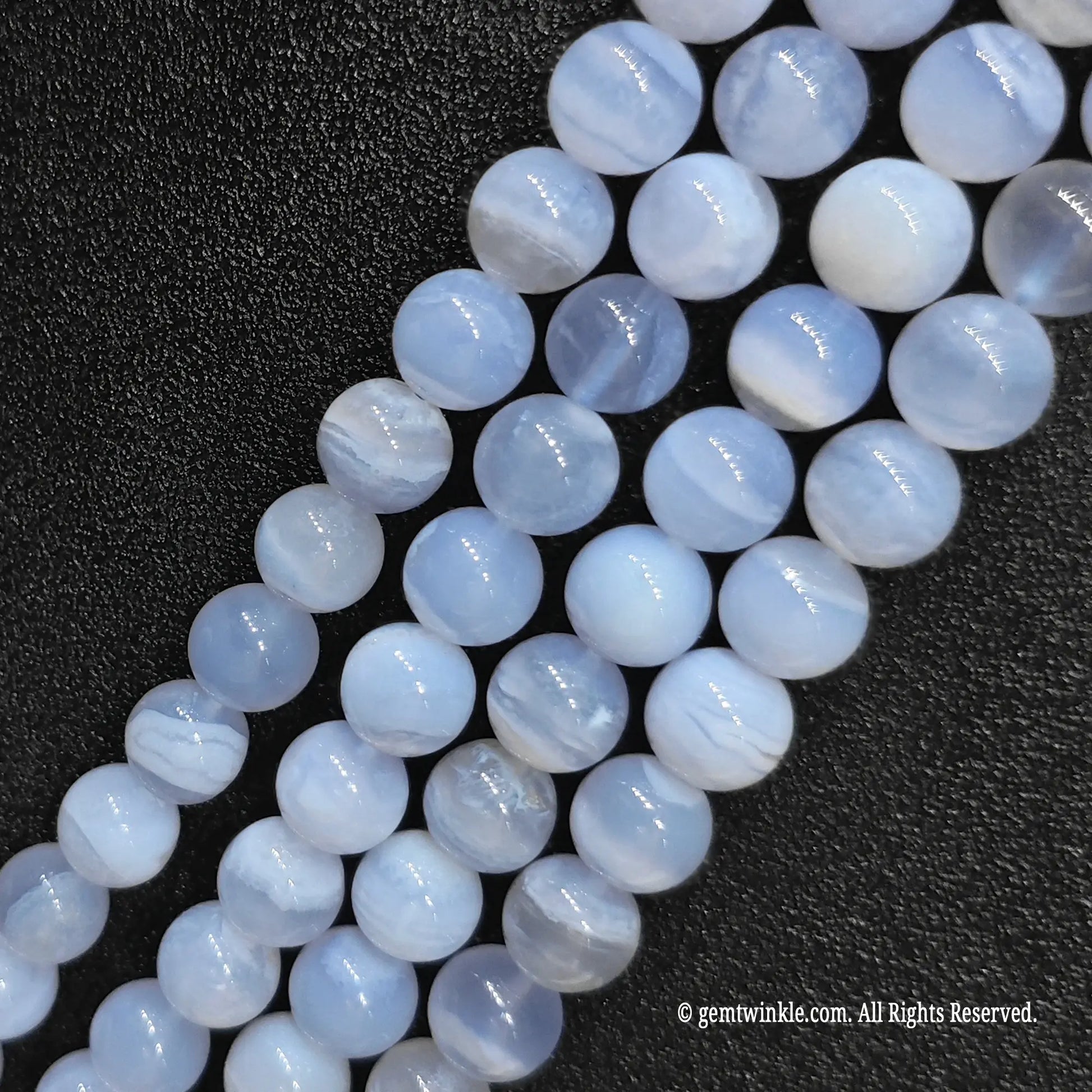 Three parallel wholesale strands of dyed blue agate crystal beads with a natural chalcedony base to verify pattern distribution