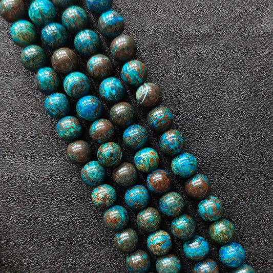Macro closeup of blue chrysocolla phoenix stone smooth round beads showing vibrant peacock matrix