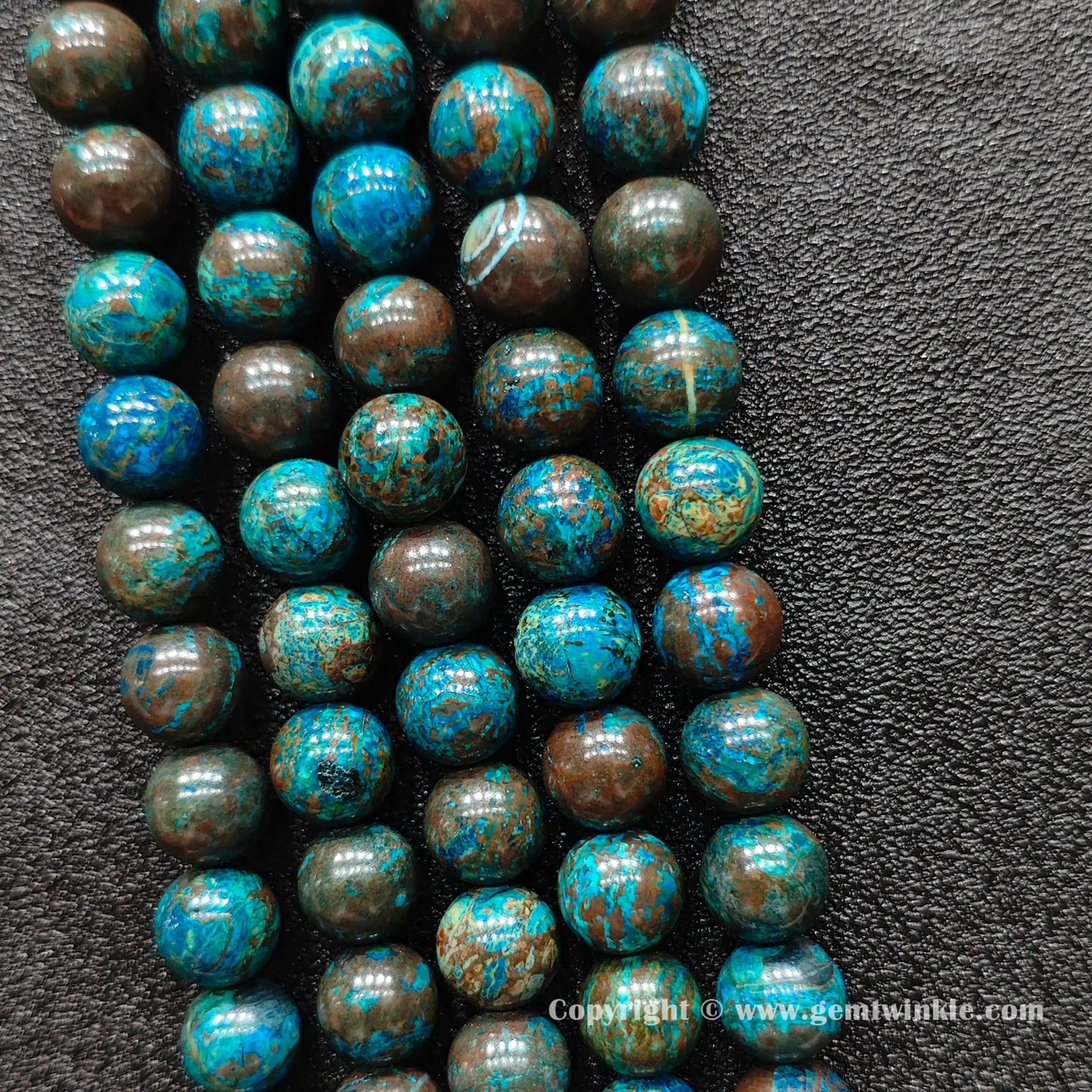 Perspective view of blue chrysocolla round beads showing polished finish across 4mm to 10mm sizes