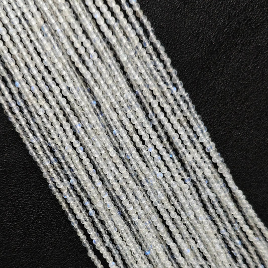 Macro closeup of 2mm blue flash moonstone smooth round seed beads showing vibrant optical blue sheen