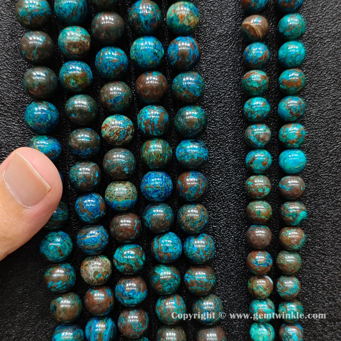 Close up view of blue phoenix stone round beads inspected on hand for natural color pattern preview
