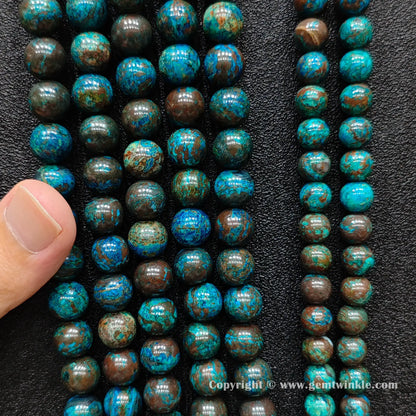Close up view of blue phoenix stone round beads inspected on hand for natural color pattern preview