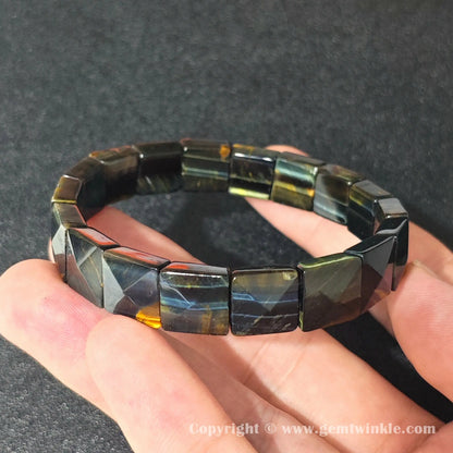 blue hawks eye curved plate bracelet resting on fingers displaying smooth machine polished surface