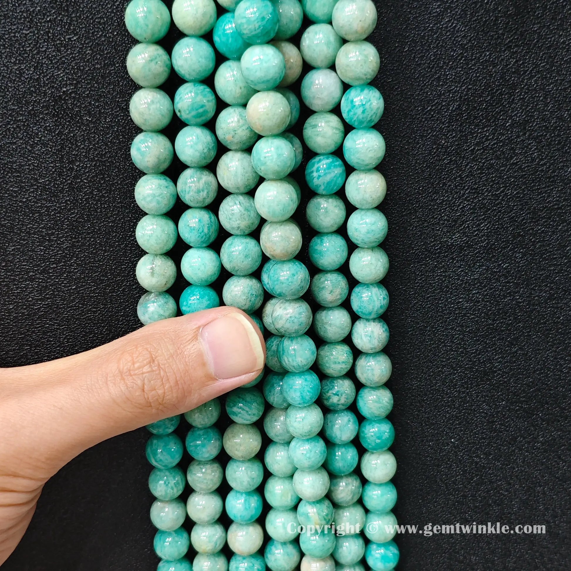Parallel strands of Grade C natural amazonite beads showing organic mineral variance and scale